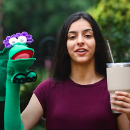 Girl holding a puppet and a straw