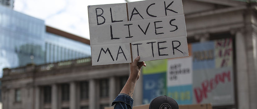 Black Lives matter sign being held up at a protest event