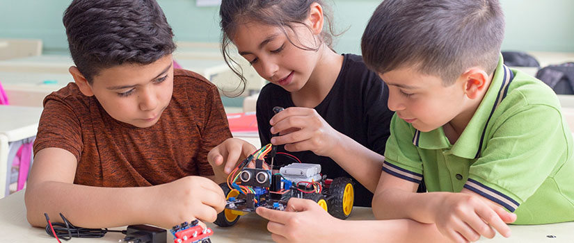 Three students assembling a robot