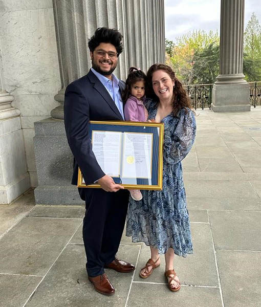 (l-r) Rohan Patel, Arya Patel and Laurann Patel on the Statehouse Grounds holding a framed document