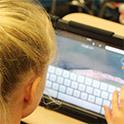 blond child using tablet computer