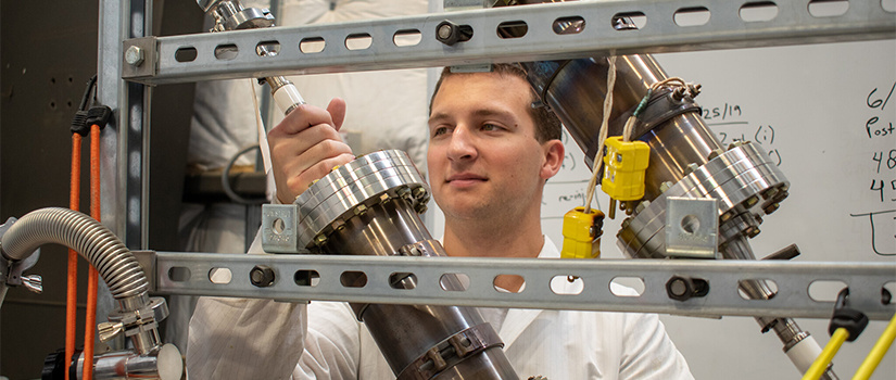 grad student works with nuclear rods