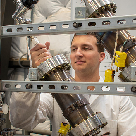 a grad student works with nuclear fuel rods