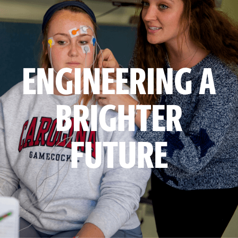 Engineering a brighter future over a photo of two female students working with electrodes in a lab