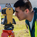 student looks through surveying equipment