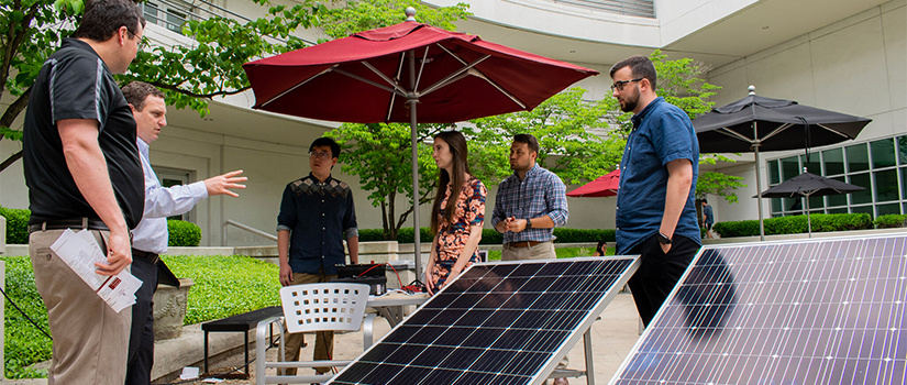 students work with solar panels in the courtyard