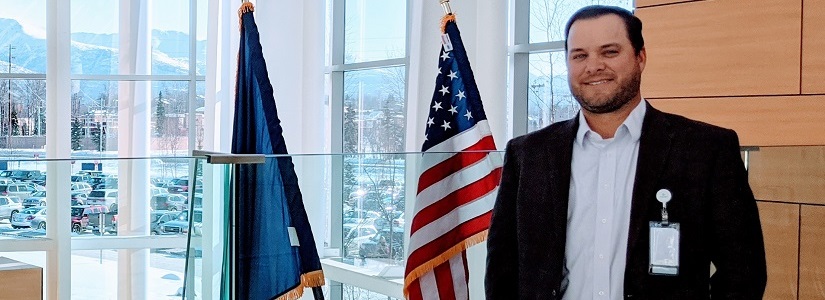 Witt stands in front of flags.