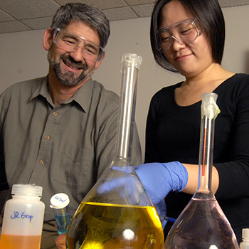 John Regalbuto works with student in lab