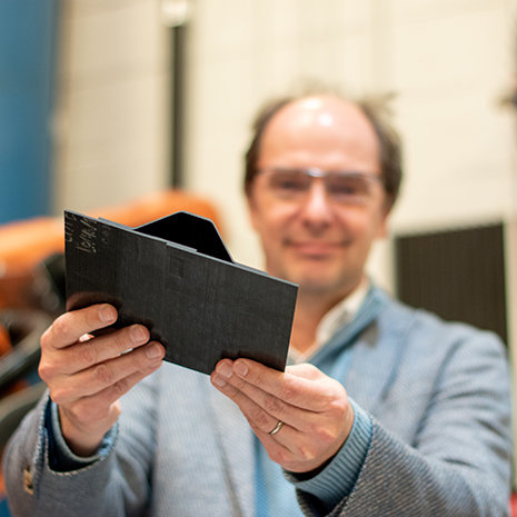 Michel Van Tooren holds a composite material