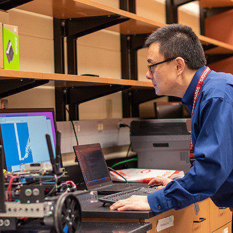 Dr. Wang works on a laptop in his lab