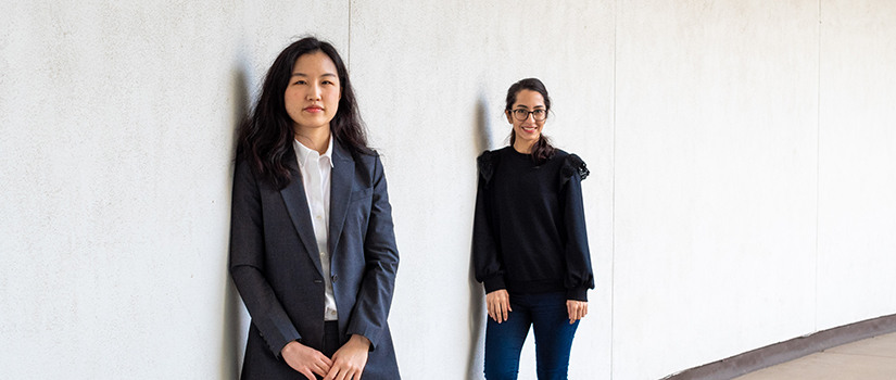 Kyung-Eun and Sepideh stand against a wall in the Swearingen courtyard.