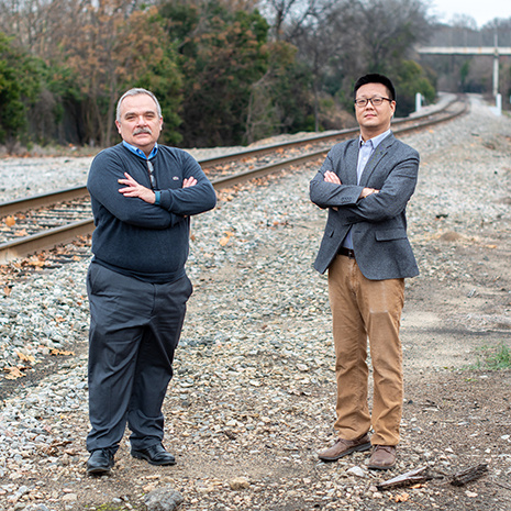 Qian and Rizos standing by the railway