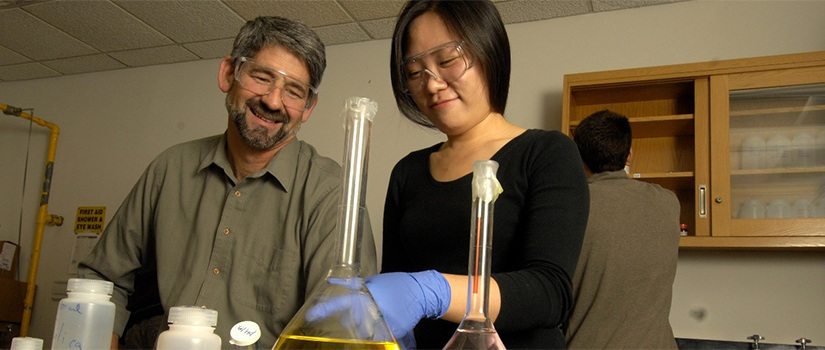 Dr. Regalbuto works with a female student in a lab
