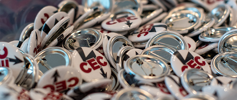 closeup on pile of buttons that say CEC