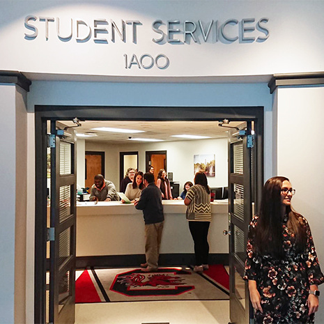outside of the student services office with staff working