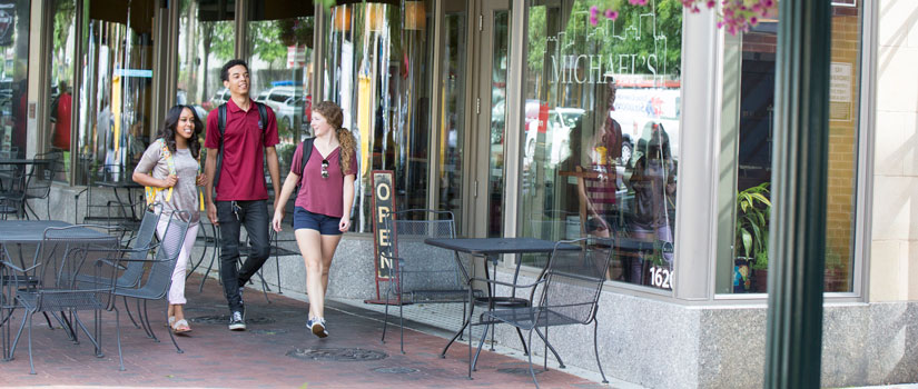 Students walk past retail stores on Main Street in downtown Columbia.
