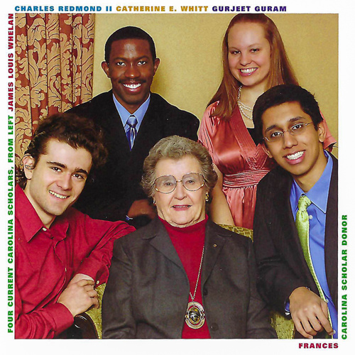 A smiling group of students posing with an older woman