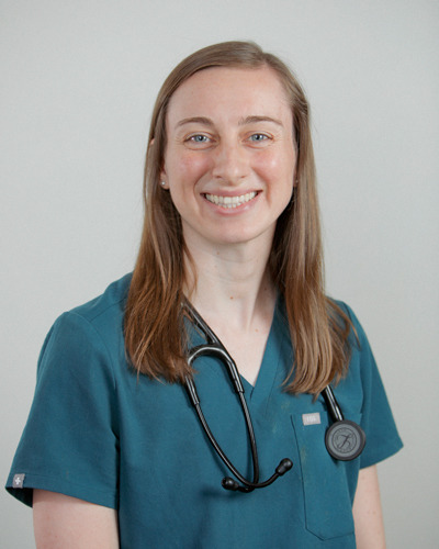 Headshot of young woman in teal scrubs