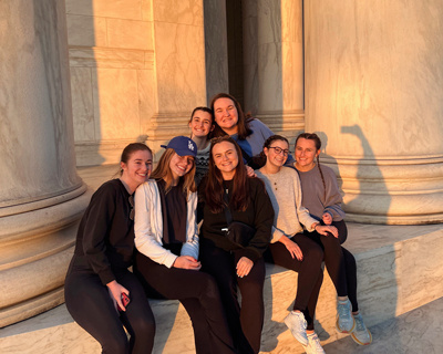 Blair Elliott posing with friends at the National mall as the sun sets.