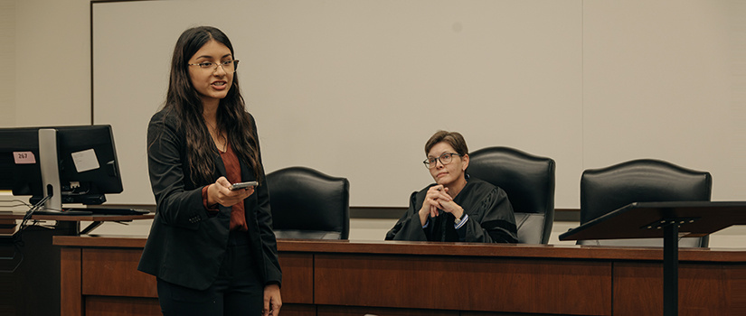 Female professor watching female student during a mock trial.