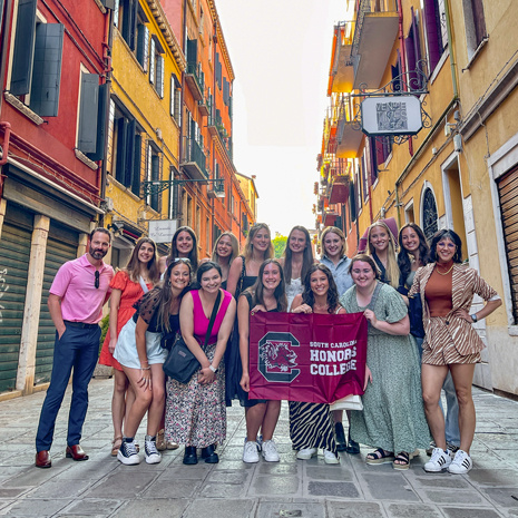 Group of SCHC 400 students holding an Honors flag in Venice.