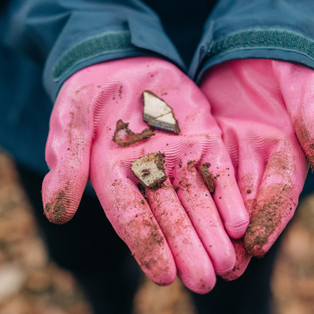 Student holding archaeological artifacts