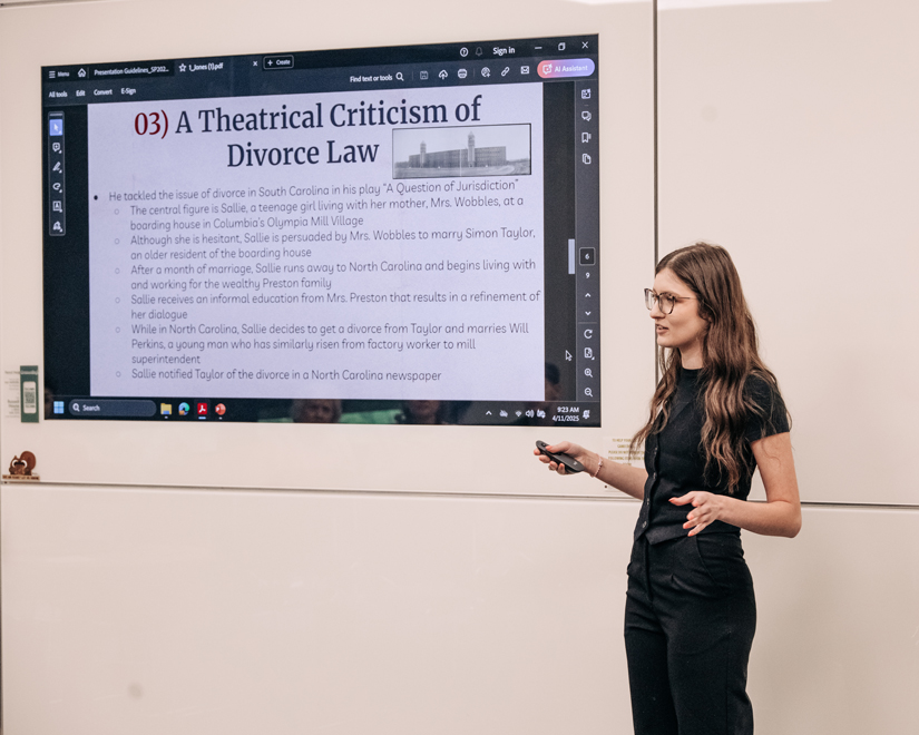 Honors student presenting senior thesis about divorce law on large screen.
