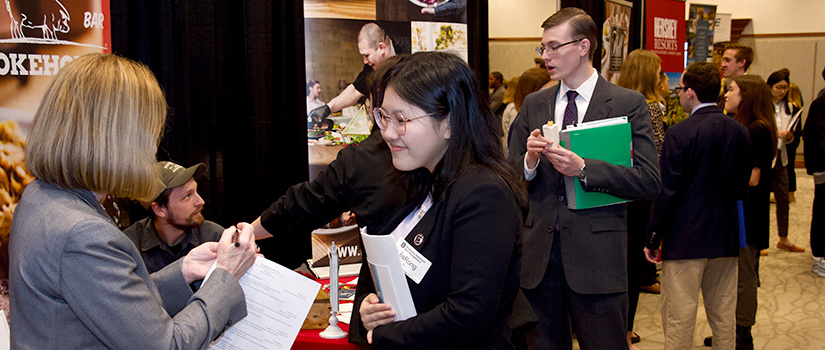 A student speaks with a recruiter at a College of HRSM 2020 Experience Expo.