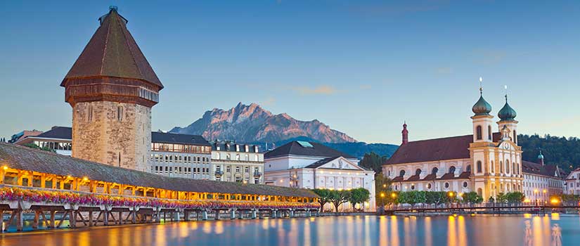 The Lucerne Campus in Switzerland sits on the banks of Lake Lucerne amidst snowy mountain peaks and lush landscape.