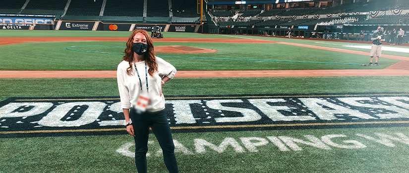 Madison Benner, sport and entertainment management alumna, stands in a Major League Baseball stadium Globe Life Field where she spent life "in a bubble."