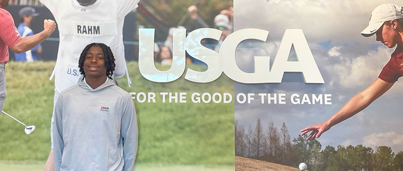 Mekhi Gibson poses in front of USGA signage
