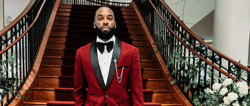 Corey Jones posed in front of a staircase