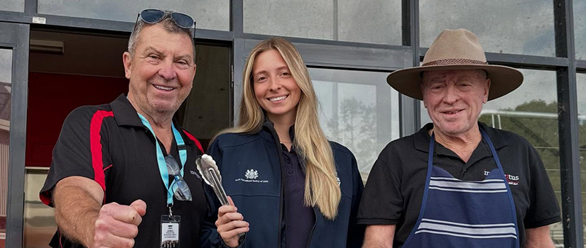 Myrtle Yates smiles with two team members while helping at a food station during the Sydney Royal Easter Show.