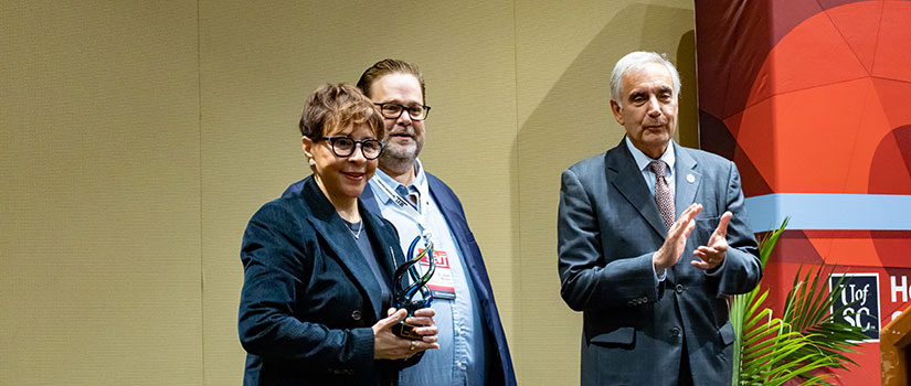 UofSC Interim President Harris Pastides and Sport and Entertainment Management Department Chair Matt Brown present an award to a conference presenter / participant at the 2021 SEVT Awards Ceremony.