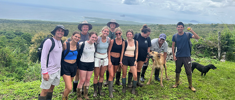 A group of students pose for a photo while visiting a farm in the Galápagos Islands.