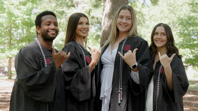 Members of Tepper Scholars cohort 1 throw up a Spurs Up hand sign