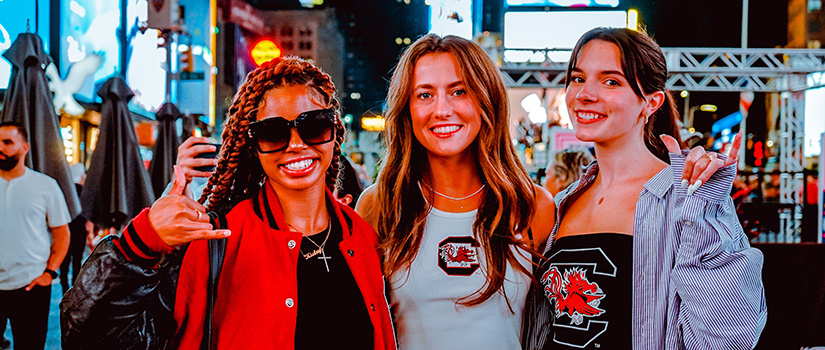 Three retailing students pose for a photo in Times Square at New York Fashion Week in September 2022.