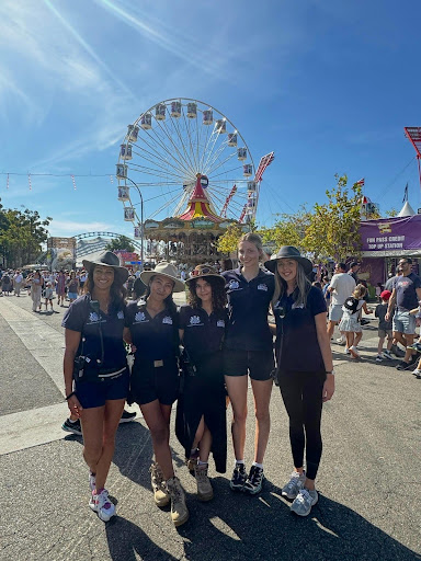 Myrtle Yates and colleagues stand in front of a Ferris wheel at the bustling Sydney Royal Easter Show.