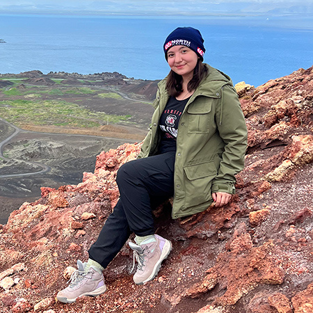 Ashlyn Ooi sitting on rocks in Iceland.