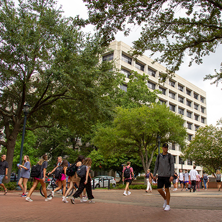 Students walk around outside the Close-Hipp Building.