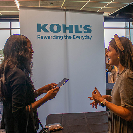A representative from Kohl's speaks with an HRSM student at the fall 2022 Experience Expo event.