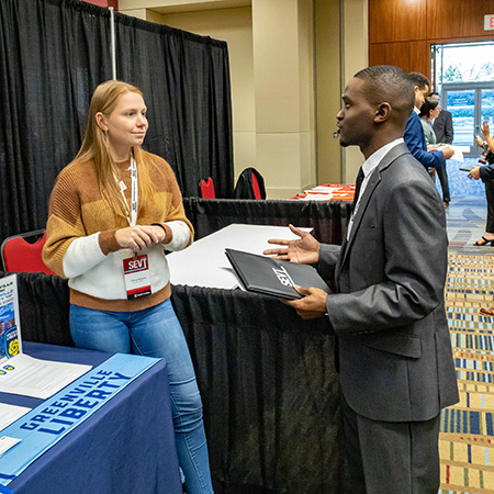 A recruiter speaks with a student at SEVT during a career fair.