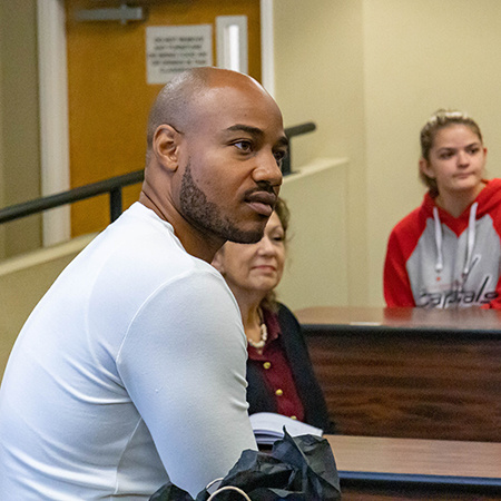 HRSM graduate Aaron Henderson looks out to the crowd at a professor for a day event.