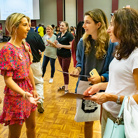 A member of the Leaders Program speaks with a prospective student at a UofSC Open House event.