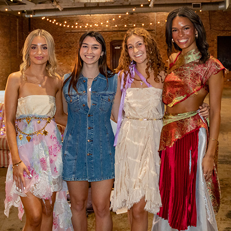 Four members of USC Fashion Board pose for a photo after a fashion show.
