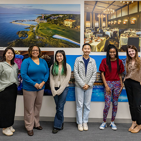 Faculty members Kathy Kim and Ashley Richardson pose for a photo with members of the National Society of Minorities in Hospitality.