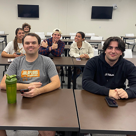 Members of the Sports Analytics Club smile for the camera at a meeting.