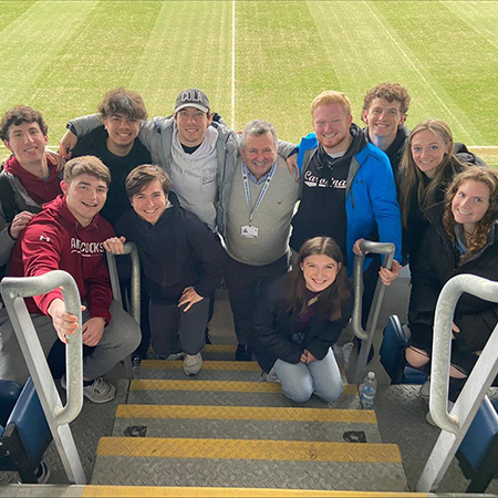 Students pose for a photo while visiting a soccer venue in England.