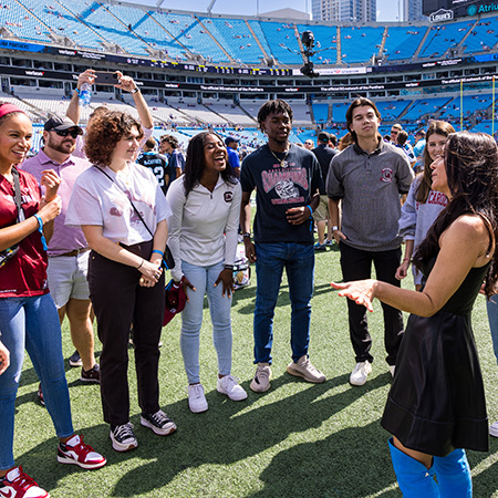 Students on the field at a Carolina Panthers game hear from owner Nicole Tepper