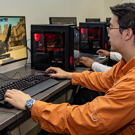 A student plays a computer game with others in the Esports Laboratory.
